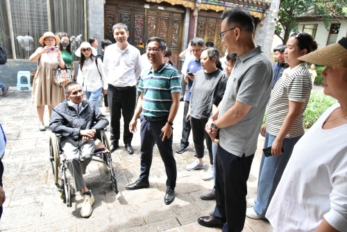 调研组领导与古渡梨园馆长——坐在轮椅上守护滇剧传承梦想的张雄先生互动交流(主图)